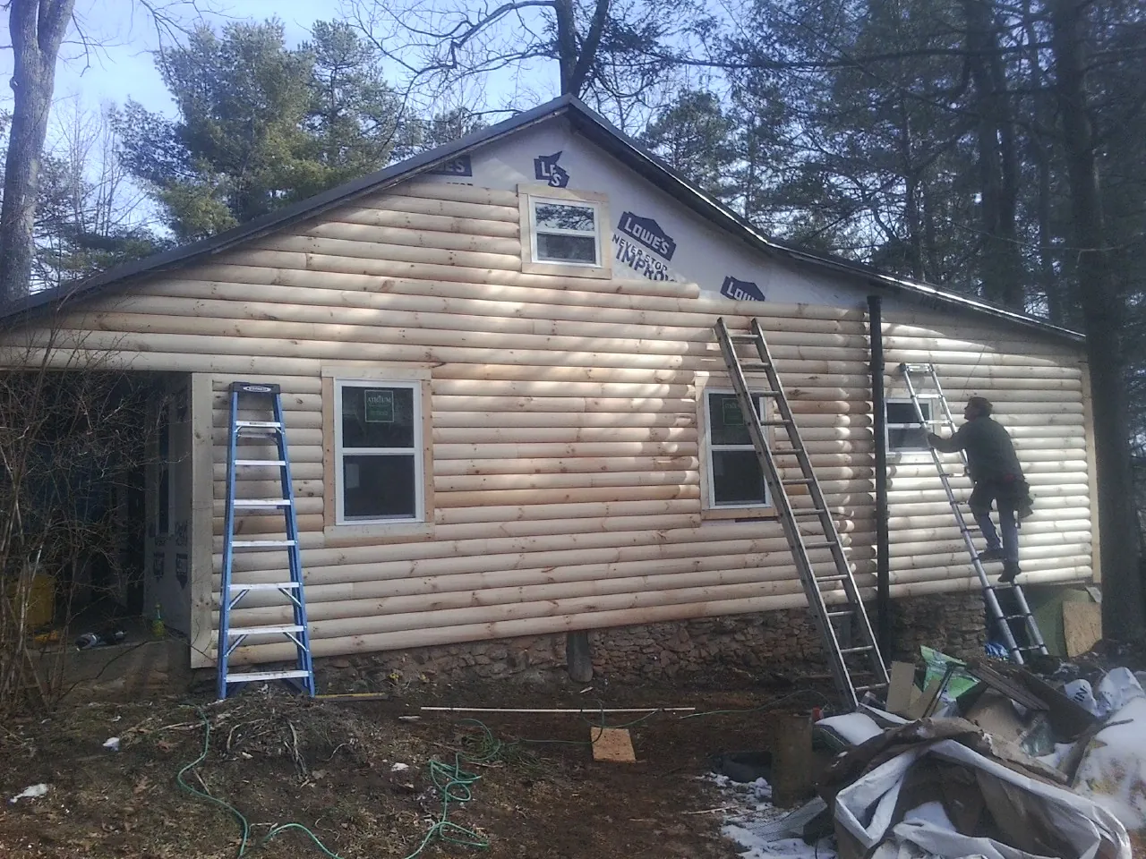Ladders set against fresh log siding during an exterior remodel in Temple City