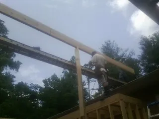Carpenter setting a ridge beam over a new addition frame — Ice Dam Removal by Roofing Brothers in Temple City