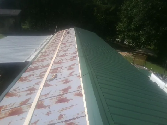 Old rusted panels beside newly installed green metal roofing — Wind Damage Roof Repair by Roofing Brothers in Temple City