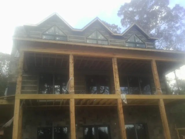 Dormers and porch framing on a large log home under construction — Roof Coating work by our crew in Temple City