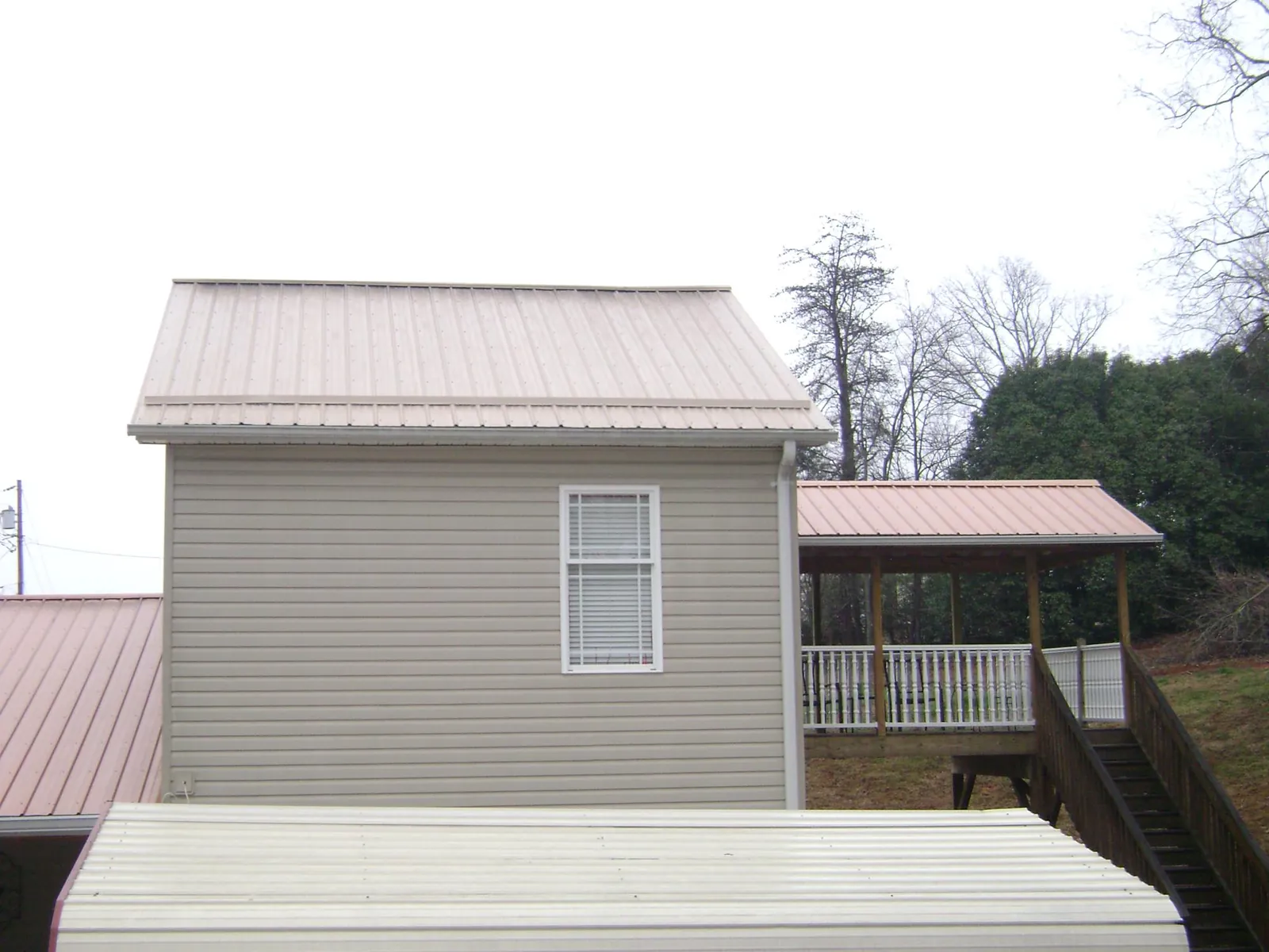 Tan metal roofs on a two story addition and attached porch, from a Roof Replacement job in Temple City